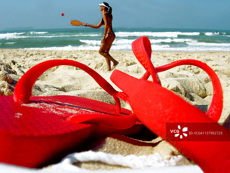 在海滩上玩球拍的女孩图片素材