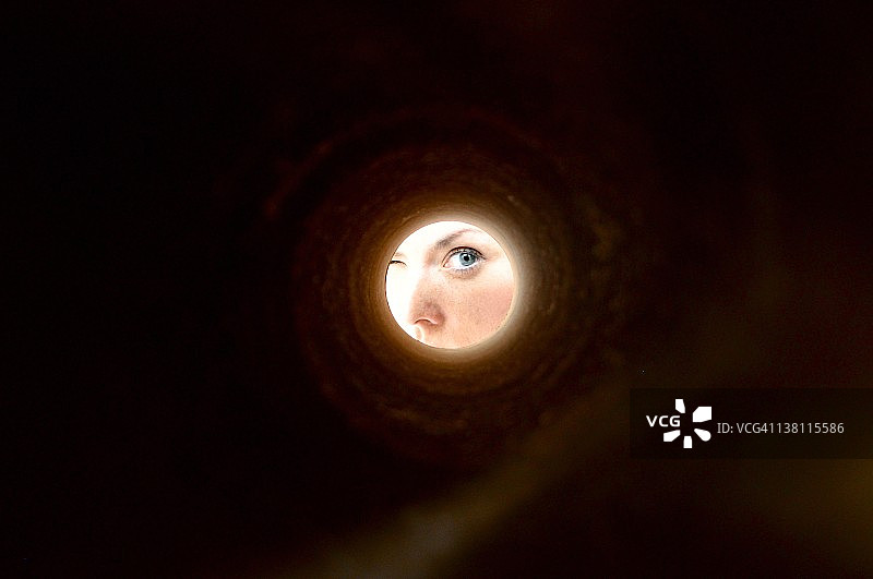 透过墙上孔洞看到的眼睛图片素材