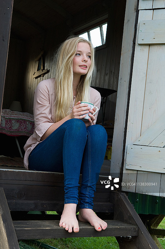 在门阶上喝咖啡的少女图片素材