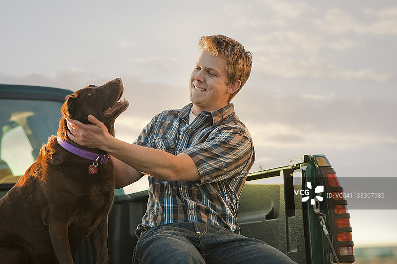 白人男子和狗坐在卡车里图片素材