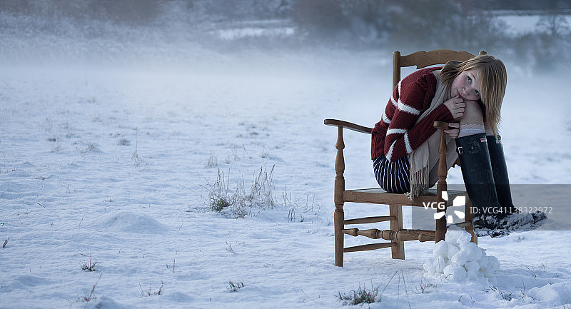 雪地里坐在椅子上的女孩图片素材