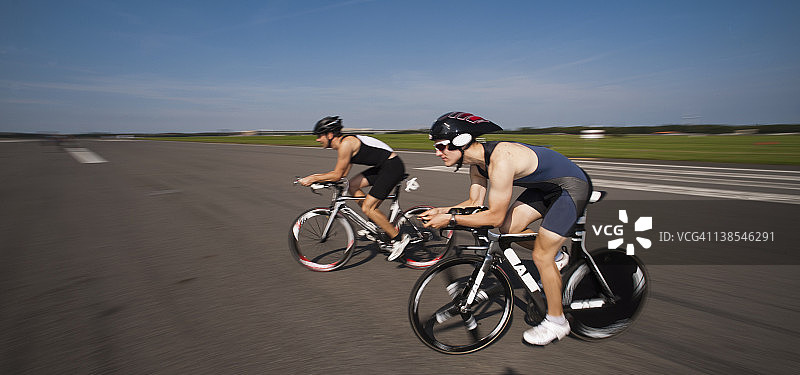 两名骑着赛车的骑自行车者，侧视图，低角度视图图片素材