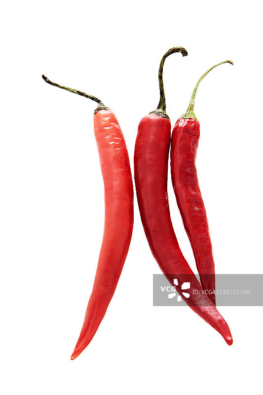 白色背景上的三个红色辣椒特写图片素材