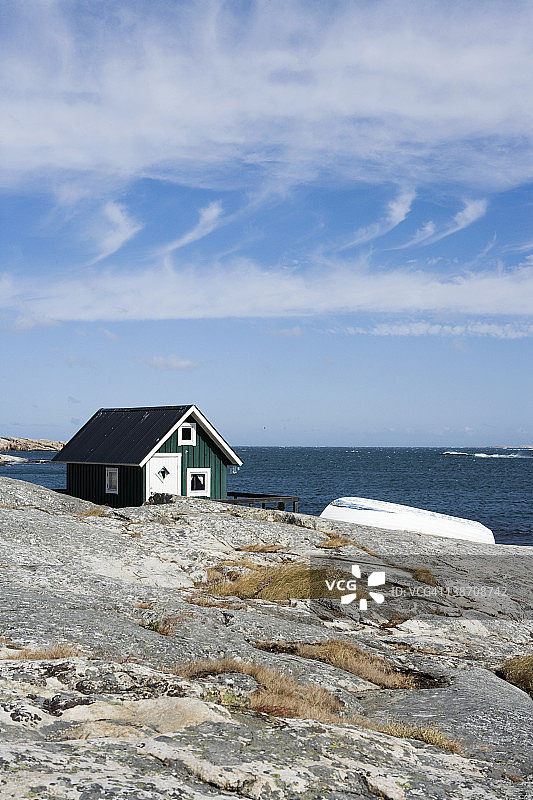 瑞典博胡斯兰，悬崖上的绿色小屋和小船图片素材