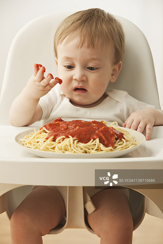 正在吃意大利面的混血男婴图片素材