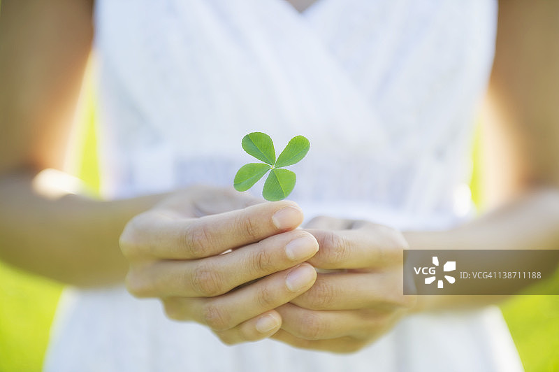 拿着四叶草的西班牙裔女人图片素材