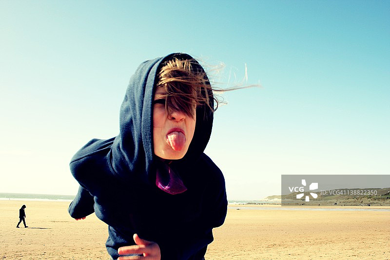 女孩在海滩上吐舌头图片素材