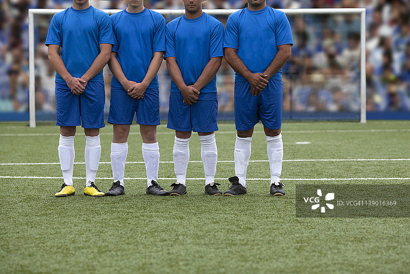 四名足球运动员在体育场组成人墙图片素材