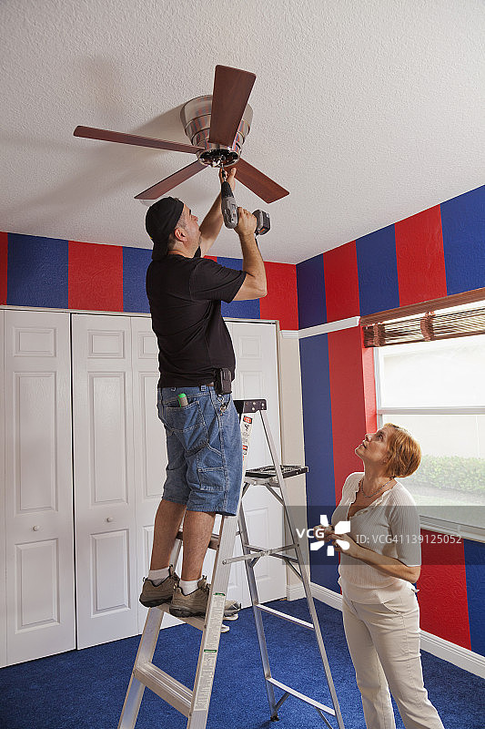 男人和女人在卧室安装吊扇图片素材