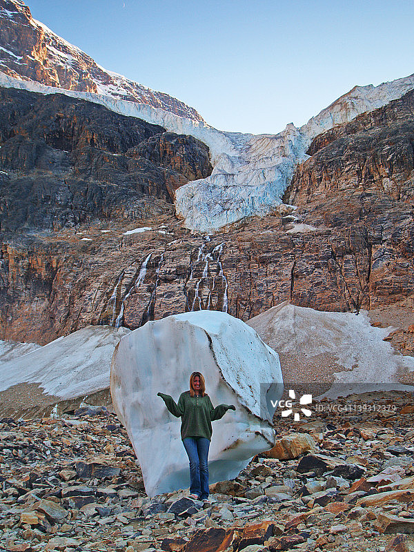 在冰川融化形成的冰块前的年轻女人图片素材