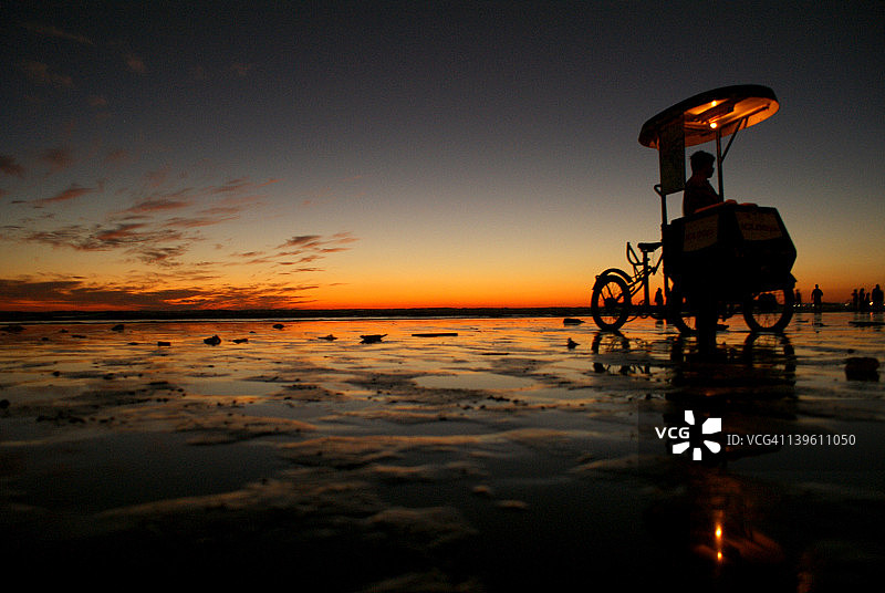 海滩黄昏时分的冰淇淋车剪影图片素材