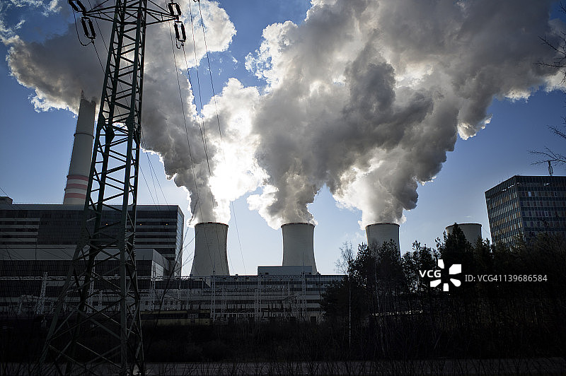 蓝天下冒着烟的发电站图片素材