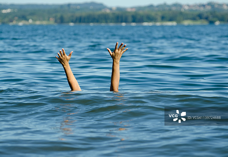 两只手臂从水中伸出寻求帮助图片素材