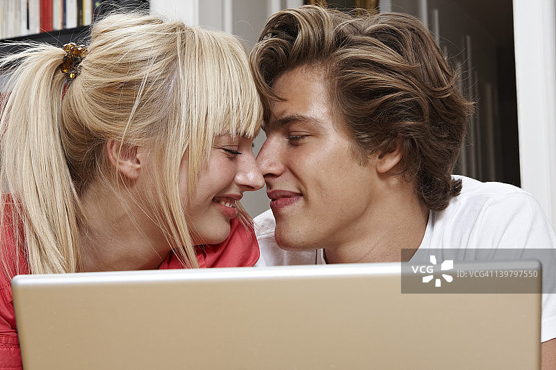 笑容灿烂的年轻情侣使用笔记本电脑图片素材