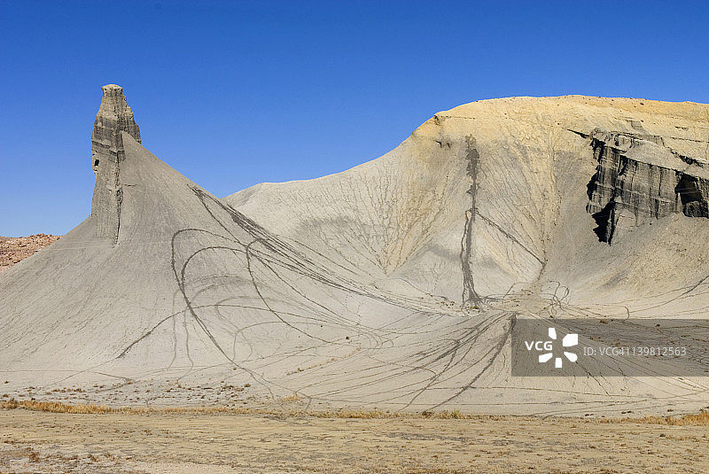 犹他州首都礁国家公园外的膨润土山坡上因越野车道留下的永久伤痕图片素材
