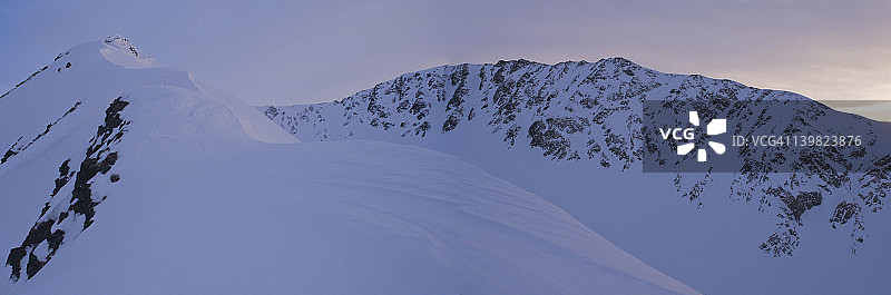 日落时分楚加奇山脉特纳根山口的雪山山顶和山脊全景图片素材