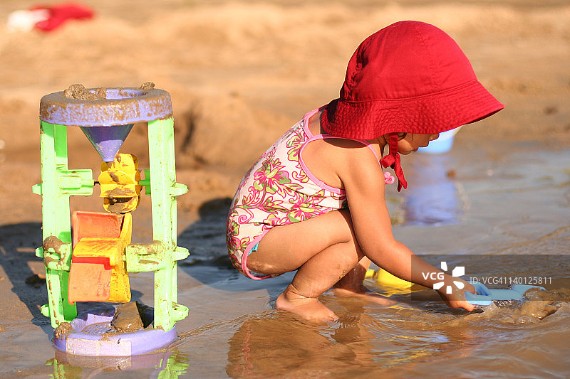 在泥地里玩耍的泳装少女图片素材