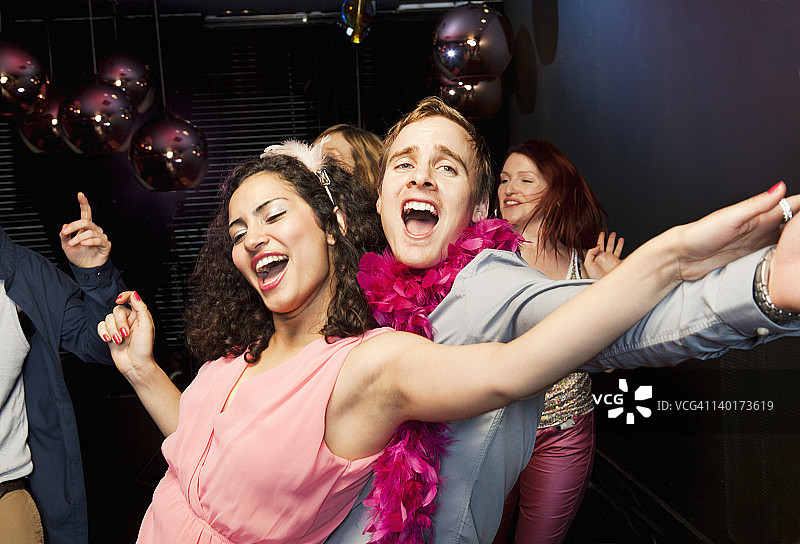 在舞池里跳舞和唱歌的情侣图片素材