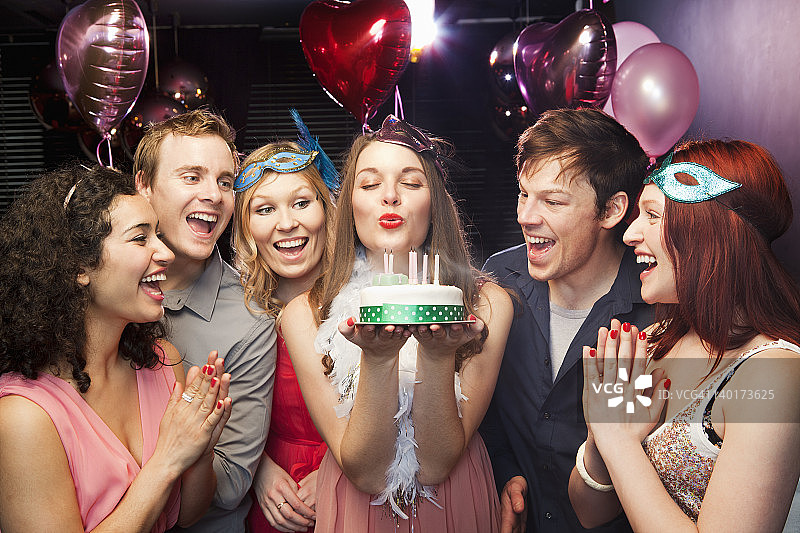 女人吹生日蛋糕上的蜡烛图片素材