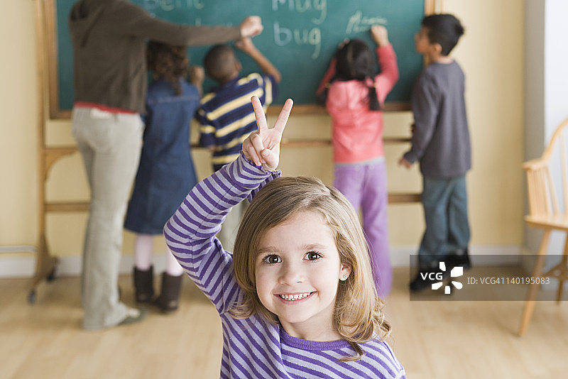 美国加利福尼亚州洛杉矶，背景是同学的微笑女孩（6-7岁）的肖像图片素材