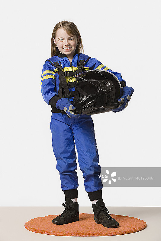 打扮成赛车手的女孩（8-9岁）的特写，工作室拍摄图片素材
