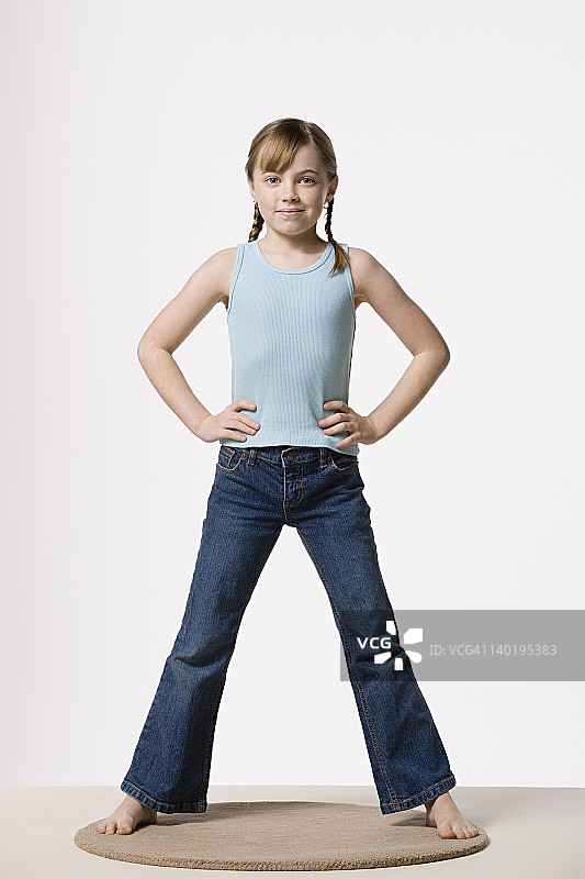 双手叉腰的女孩肖像（8-9岁），影棚拍摄图片素材