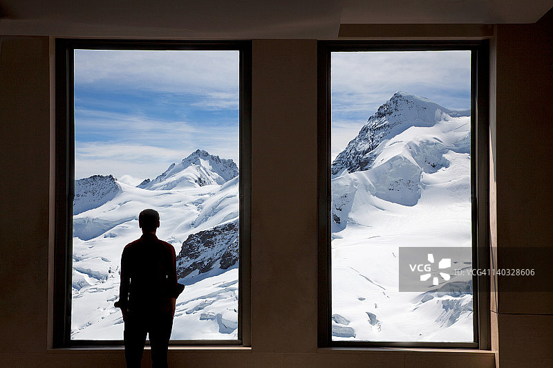 向窗外看的年轻男子图片素材