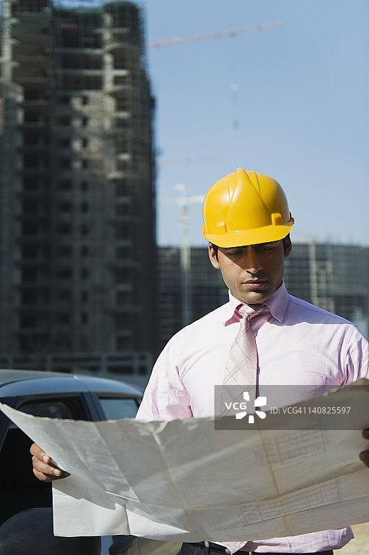 建筑师在印度哈里亚纳邦古尔冈的建筑工地看蓝图图片素材
