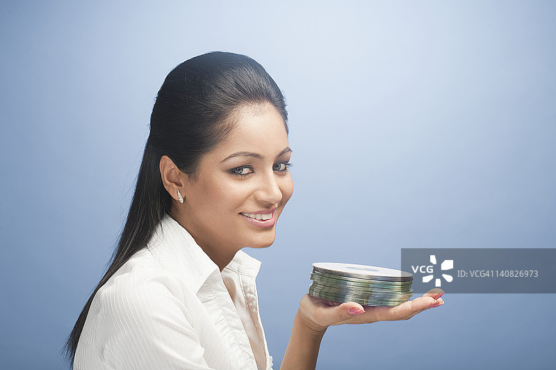 女人拿着一堆CD并微笑图片素材