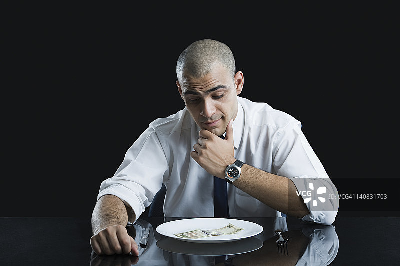 商人看着盘子里的钱图片素材