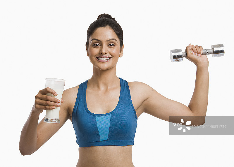 女人手持牛奶杯和哑铃锻炼图片素材