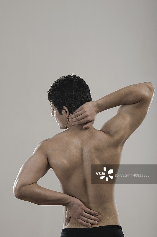 因背痛而痛苦的健壮男人图片素材
