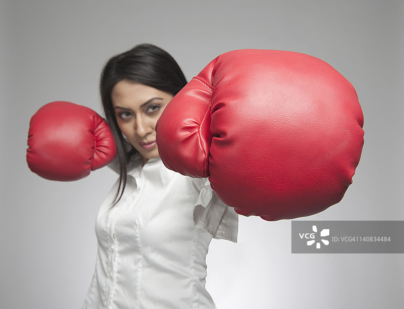 女商人戴着拳击手套猛击图片素材