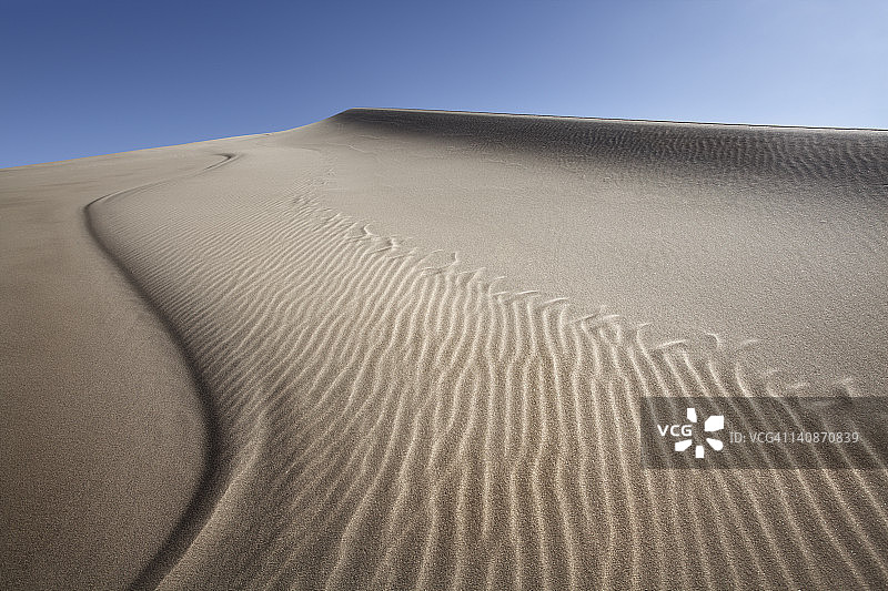 蓝色天空下的沙丘纹理图片素材