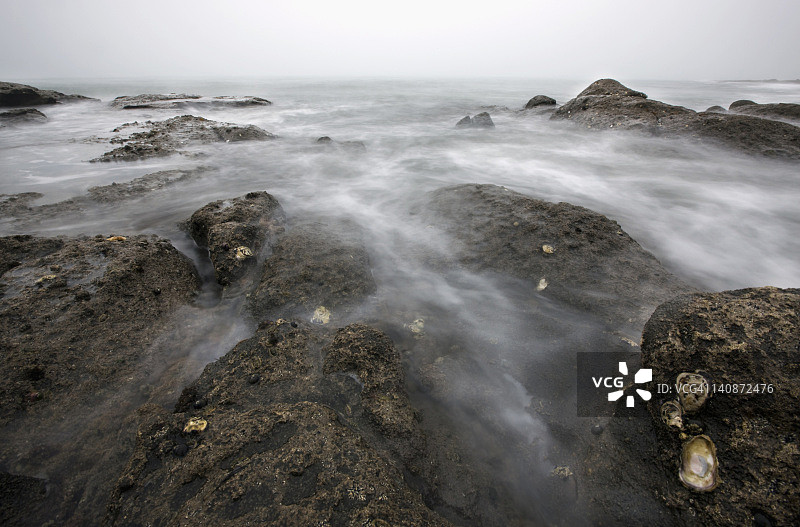 海滩上被水冲刷的岩石图片素材