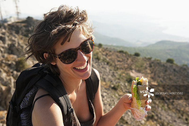徒步旅行者在山丘上吃三明治图片素材