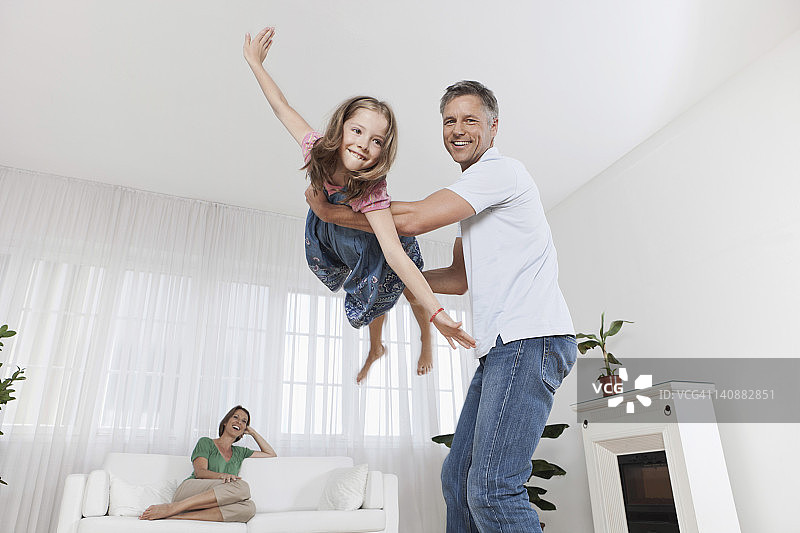 德国慕尼黑父亲和女儿玩耍，母亲在背景中图片素材