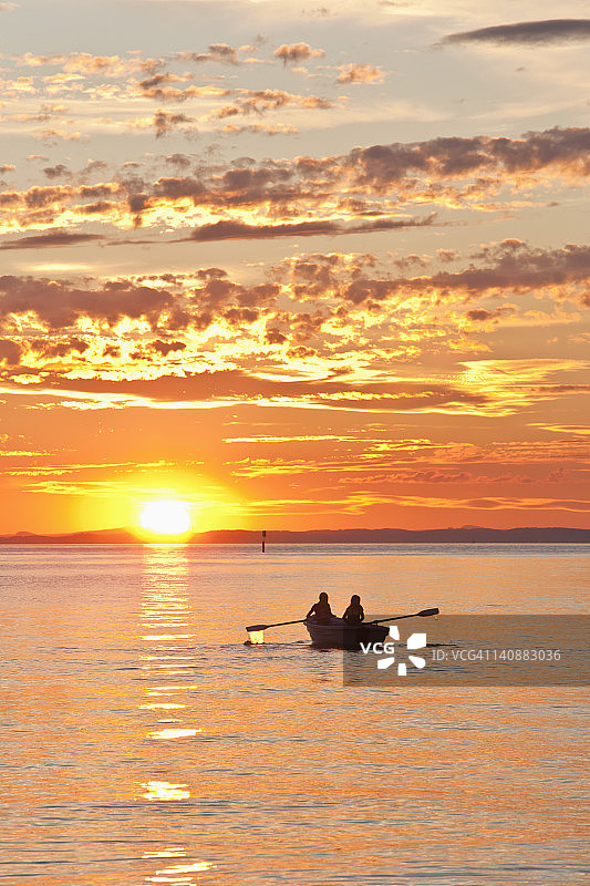 德国巴登-符腾堡州朗根阿根，日落时船上的人们图片素材