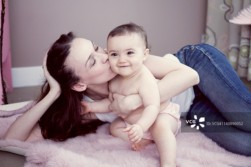 母亲亲吻女婴，特写图片素材