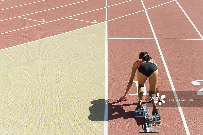 在跑道上以起跑姿势蹲着的女人（背面）图片素材