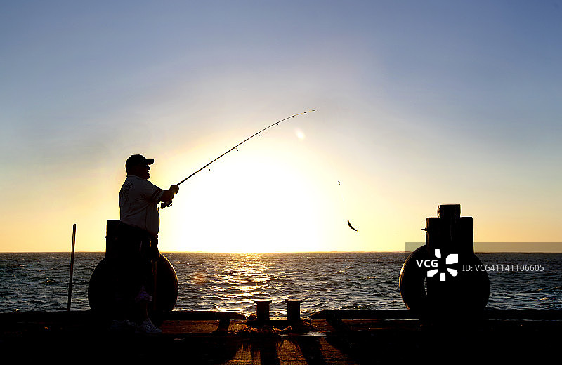 日落时分在印度洋捕鱼的男人图片素材
