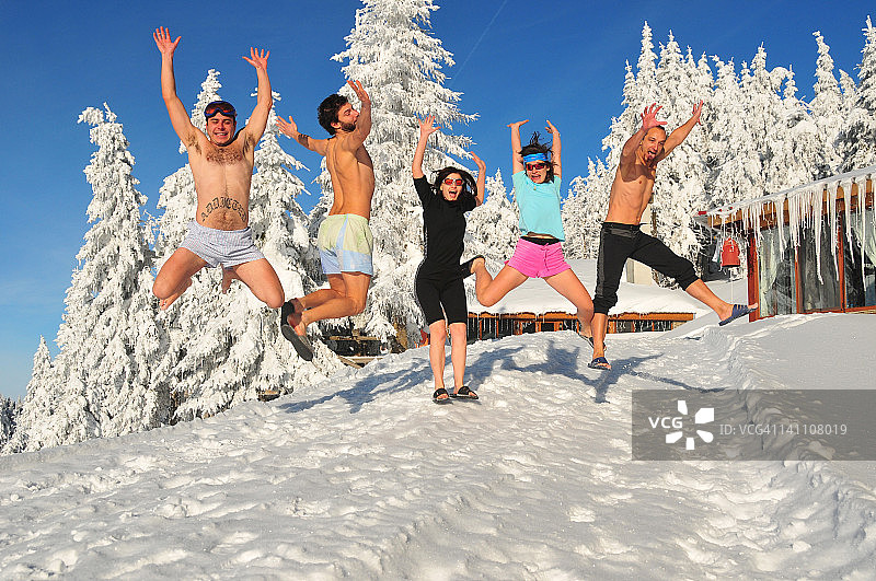 人们在山前雪地上跳跃图片素材