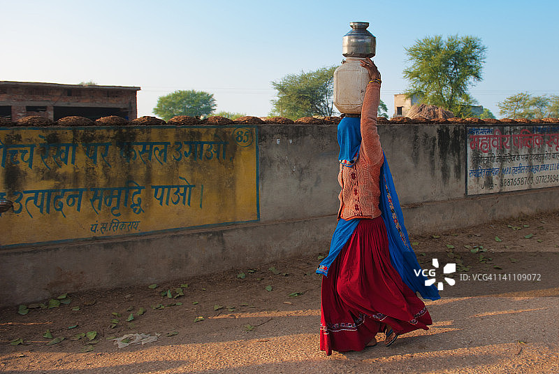 头顶塑料盆的女人图片素材
