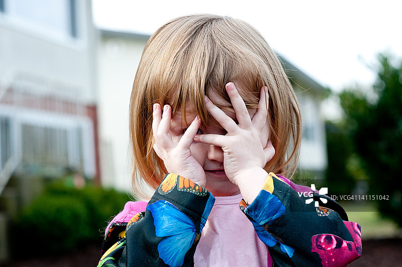 在院子里玩躲猫猫的小女孩图片素材