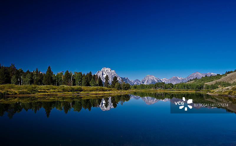 清澈蓝湖中倒映的群山图片素材