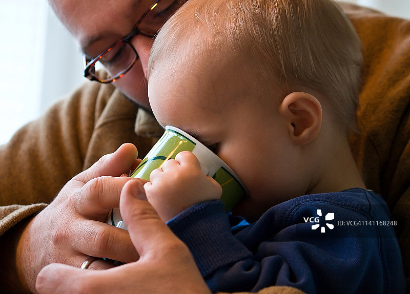 男孩和父亲一起饮用图片素材