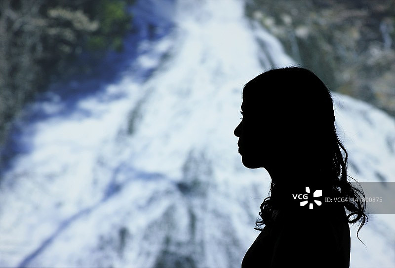 站在瀑布中的女性轮廓图片素材