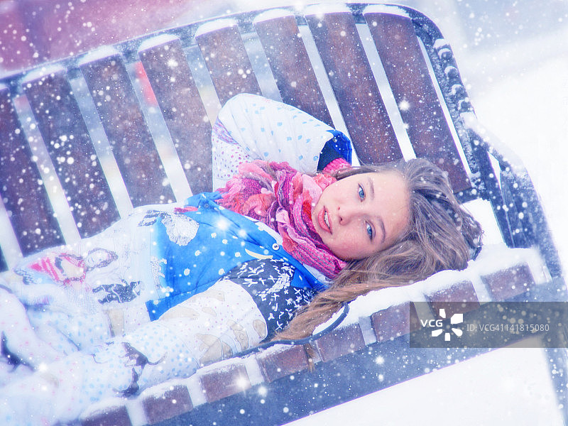 女孩躺在雪枝上图片素材