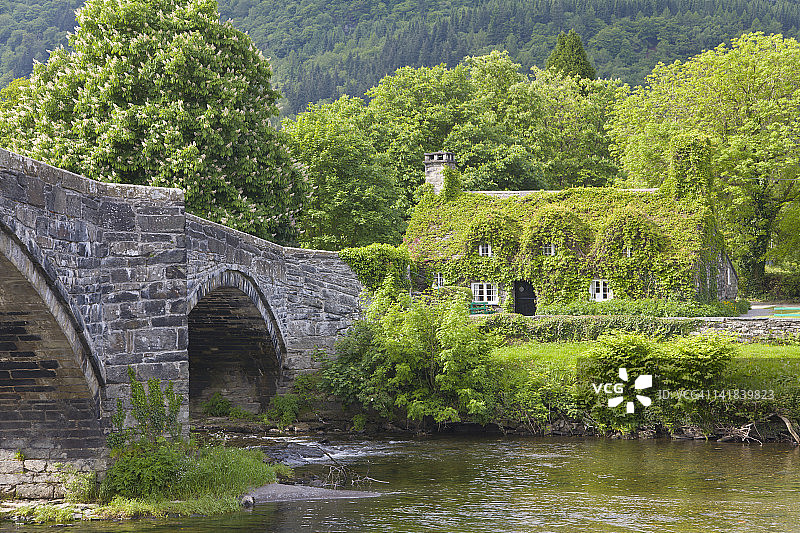 康威北部Llanrwst的常春藤覆盖的小屋和伊尼戈·琼斯桥图片素材