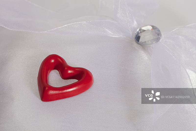 缎面枕头上的红色爱心与仿制钻石图片素材